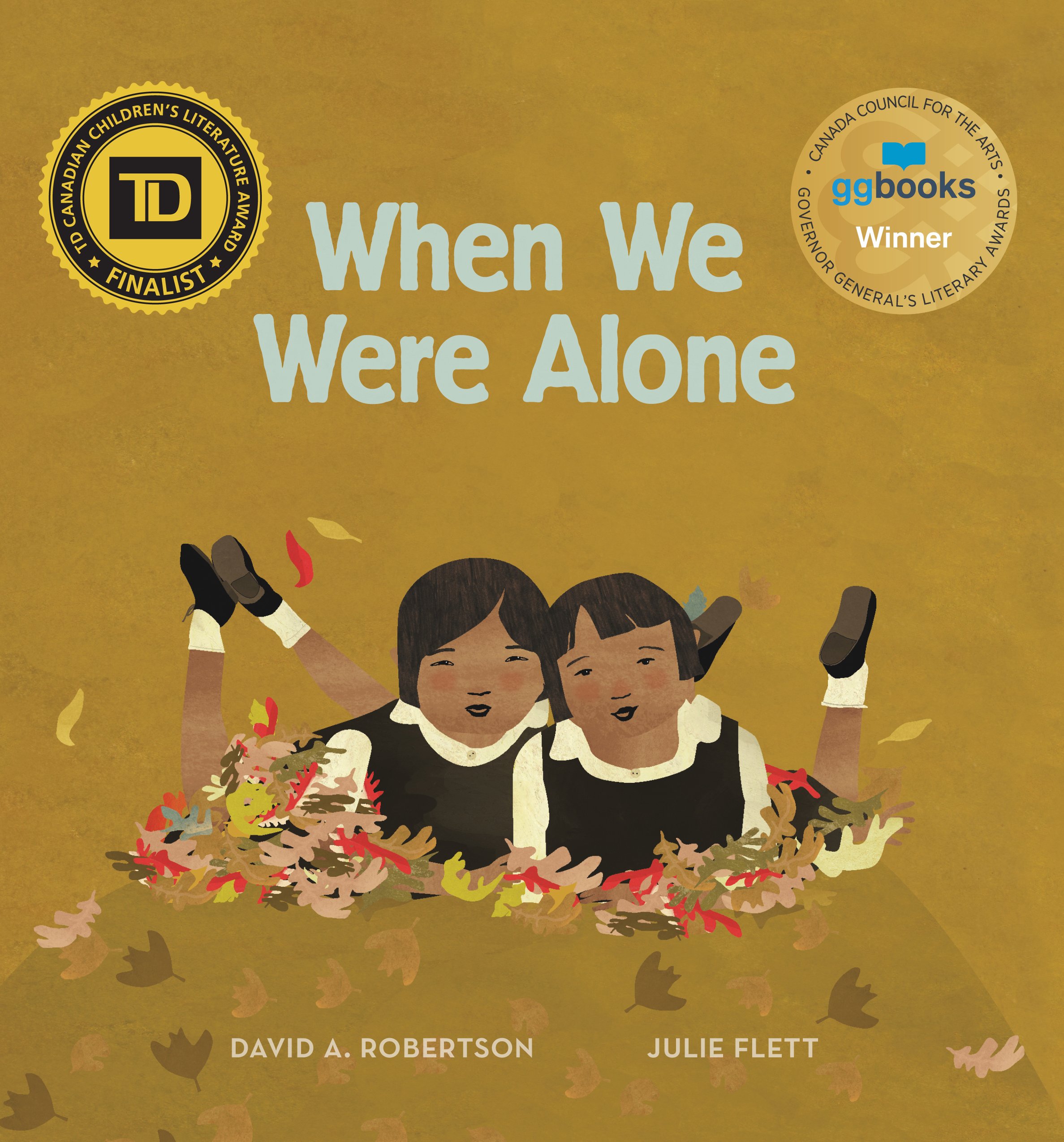 When We Were Alone book cover: gold background with two girls laying in a pile of leaves.